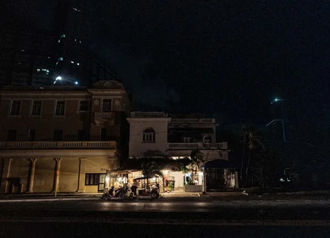 Orang-orang berkumpul di dekat toko  dengan generator listrik selama pemadaman listrik nasional di Havana,  Kuba, Sabtu (21/03/3026) waktu setempat.