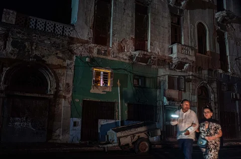 Orang-orang berjalan di jalan tanpa aliran listrik selama pemadaman listrik nasional di Havana, Kuba, Sabtu (21/03/3026) waktu setempat.