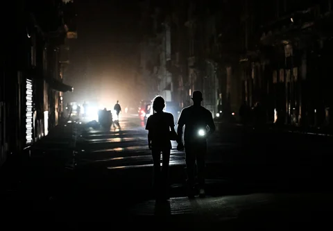 Orang-orang berjalan di jalan tanpa aliran listrik selama pemadaman listrik nasional di Havana, Kuba, Sabtu (21/03/3026) waktu setempat.