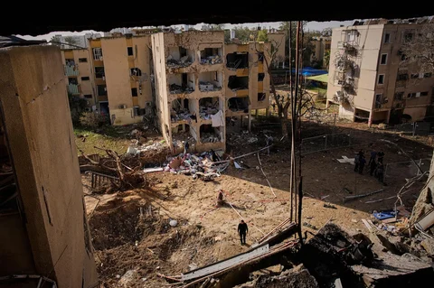 Warga melihat bangunan tempat tinggal yang rusak akibat serangan rudal Iran di Arad, Israel selatan, Minggu (22/03/2026).