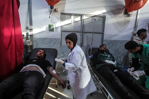 Paramedis merawat korban luka dari jip polisi Palestina yang menjadi sasaran serangan udara Israel di kamp pengungsi Nuseirat di Jalur Gaza, Minggu (22/03/2026).
