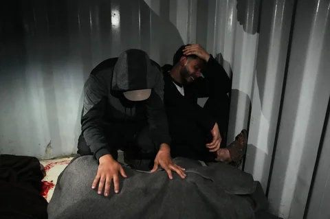 Warga Palestina berduka atas jenazah Ahmed Tabasha, seorang polisi Palestina yang tewas dalam serangan militer Israel, di Rumah Sakit Al-Awda di Nuseirat, Jalur Gaza selatan, Minggu (22/03/2026).