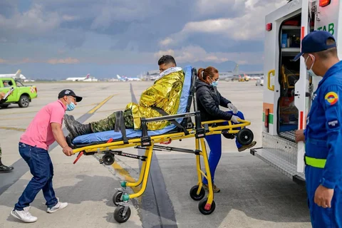 Anggota Angkatan Udara Kolombia dan paramedis membawa seorang korban luka di pangkalan udara CATAM di Bogota, Kolombia, Senin (23/03/2026) waktu setempat.
