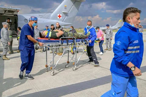 Anggota Angkatan Udara Kolombia dan paramedis membawa seorang korban luka di pangkalan udara CATAM di Bogota, Kolombia, Senin (23/03/2026) waktu setempat.