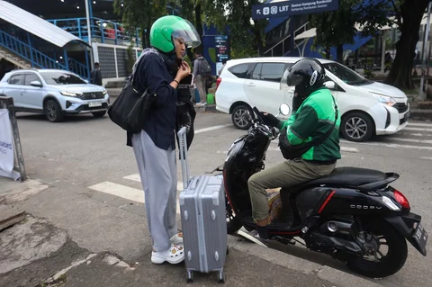 Pemudik memesan ojek online usai tiba di Teminal Kampung Rambutan, Jakarta, Rabu (25/03/3036).