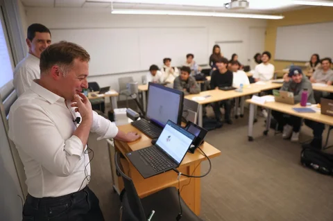 Profesor Panos Ipeirotis berbicara dengan agen AI lisan suara selama perkuliahan di NYU Stern School of Business, New York, (04/03/2026).
