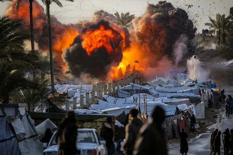 Bola api meletus setelah serangan Israel di dekat perkemahan tenda yang menampung orang-orang yang mengungsi akibat perang di Deir el-Balah di Jalur Gaza tenga,  Rabu (25/03/2026).