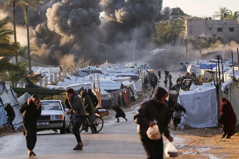 Warga terkejut setelah serangan Israel di dekat perkemahan tenda yang menampung orang-orang yang mengungsi akibat perang di Deir el-Balah di Jalur Gaza tenga,  Rabu (25/03/2026).