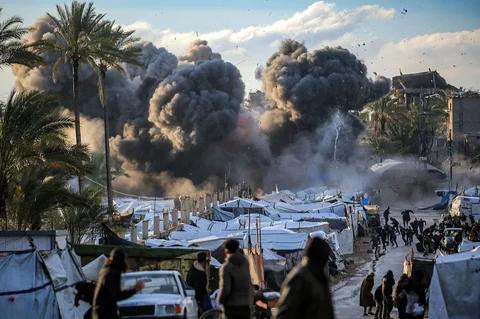 Warga terkejut setelah serangan Israel di dekat perkemahan tenda yang menampung orang-orang yang mengungsi akibat perang di Deir el-Balah di Jalur Gaza tenga,  Rabu (25/03/2026).
