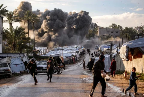 Warga berlarian setelah serangan Israel di dekat perkemahan tenda yang menampung orang-orang yang mengungsi akibat perang di Deir el-Balah di Jalur Gaza tenga,  Rabu (25/03/2026).