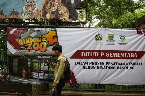 Seorang pria berjalan melewati gerbang masuk Kebun Binatang Bandung yang tertutup di Bandung, Jawa Barat, Kamis (26/03/2026).