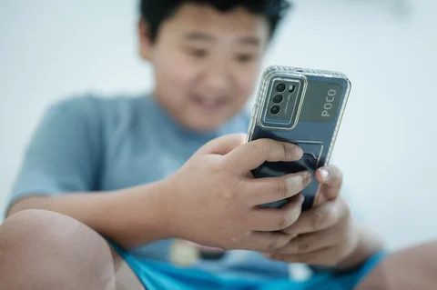 Seorang anak laki-laki berusia 11 tahun menonton video media sosial pada ponsel pintarnya di Jakarta,  (25/03/2026).