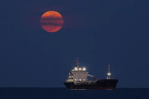 Bulan darah terbit di atas Laut Mediterania tempat sebuah kapal berlabuh, di Limassol, Siprus, Selasa (03/03/2026) waktu setempat.