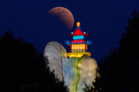 Bulan terlihat sesaat sebelum gerhana total di dekat sebuah lampion di Beijing, Selasa, (03/03/2026).
