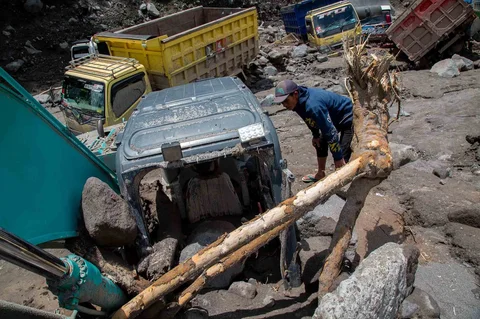 Warga  memeriksa truk yang terkubur di pasir setelah banjir lahar dingn  dari Gunung Merapi di Sungai Senowo di Magelang, Jawa Tengah, Rabu (04/03/20026).