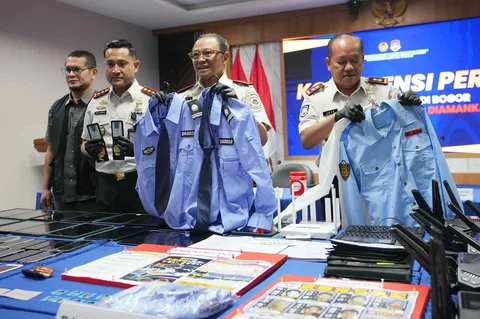 Petugas Imigrasi menunjukkan barang bukti yang disita dari warga negara Jepang yang diduga terlibat dalam sindikat penipuan daring, saat konferensi pers di Bogor, Indonesia, Rabu (04/03/2026).