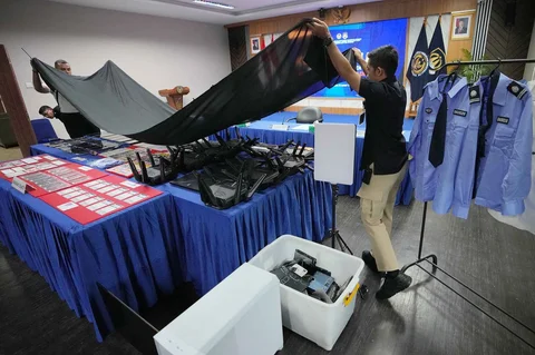 Petugas Imigrasi Indonesia menutupi barang bukti yang disita dari warga negara Jepang yang diduga terlibat dalam sindikat penipuan daring, selama konferensi pers di Bogor, Rabu, 4 Maret 2026.