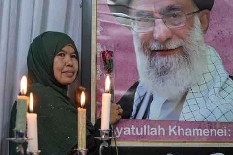 Seorang pelayat berpose di samping potret pemimpin tertinggi Iran Ayatollah Ali Khamenei, di kediaman Duta Besar Iran di Jakarta, Kamis, (05/03/2026).