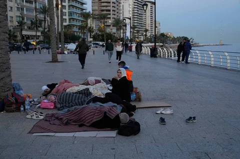 Para pengungsi yang melarikan diri dari serangan udara Israel di pinggiran selatan Beirut, Dahiyeh, duduk di tepi pantai Beirut, Lebanon, Jumat, (06/03/2026).