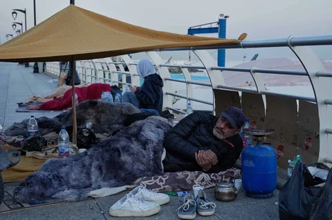 Para pengungsi yang melarikan diri dari serangan udara Israel di pinggiran selatan Beirut, Dahiyeh, duduk di tepi pantai Beirut, Lebanon, Jumat, (06/03/2026).