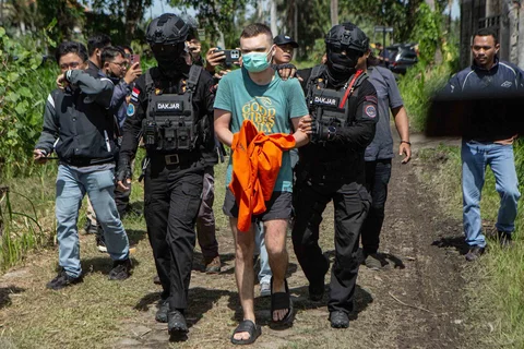 Tersangka warga negara Rusia S.T. (C), 34 tahun, yang dituduh mengoperasikan laboratorium yang memproduksi narkoba sintetis mephedrone, dikawal polisi ke rumah yang digunakan untuk memproduksi narkoba saat rekonstruksi di Gianyar, Bali, Sabtu (07/03/2026).