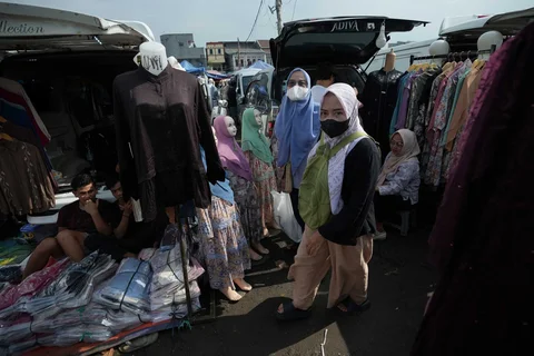 Warga berjalan melewati kendaraan pedagang yang menjual pakaian di Pasar Tasik, Cideng, Jakarta, Senin, (09/03/2026).