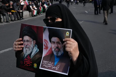 Seorang wanita memegang poster Ayatollah Mojtaba Khamenei bersama foto mendiang Ayatollah Ali Khamenei saat unjuk rasa dukungan di Teheran Iran Senin 9 Maret 2026.