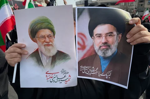 Seorang wanita memegang poster Ayatollah Mojtaba Khamenei bersama foto mendiang Ayatollah Ali Khamenei saat unjuk rasa dukungan di Teheran Iran Senin 9 Maret 2026.
