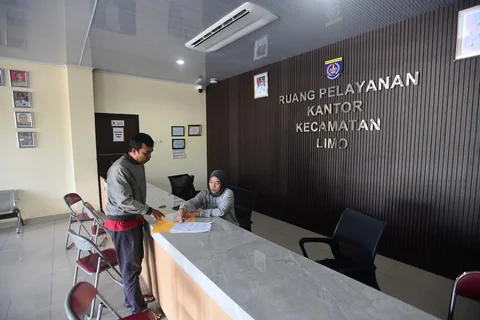 Staf bekerja  melayani warga masyarakat  saat penerapan work from home (WFH) bagi aparatur sipil negara (ASN)  di kantor Kecamatan Limo, Depok, Jumat (10/04/2026).