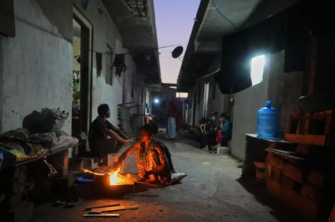 Seorang perempuan migran menyiapkan makanan menggunakan kayu bakar di sebuah tempat tinggal pekerja keramik yang sepi di Morbi, negara bagian Gujarat, India, Rabu (08/04/2026).