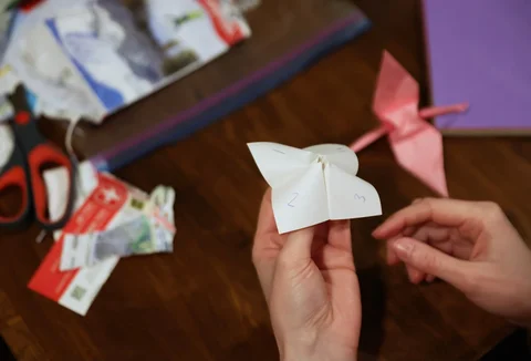 Para tamu memainkan permainan origami selama pertemuan mingguan tanpa telepon di rumah penyelenggara Dan Fox di distrik Brooklyn, New York, AS, (25/03/2026).