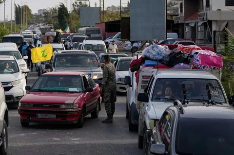 Tentara Lebanon memberi isyarat kepada pengungsi yang mengantre menyeberangi jembatan rusak di Qasmiyeh, dekat Tyre, saat kembali mereka kembali ke desa pasca gencatan senjata, Jumat (17/04/2026).