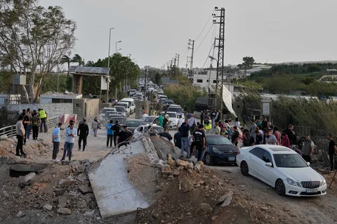 Warga mengantre menyeberangi jembatan rusak di Qasmiyeh, dekat Tyre, saat kembali mereka kembali ke desa pasca gencatan senjata, Jumat (17/04/2026).