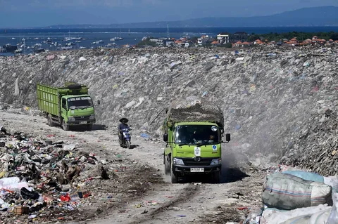 Kendaraan mengangkut sampah melintas di dekat tumpukan sampah di tempat pembuangan sampah Suwung di Denpasar, Jumat (17/04/2026).