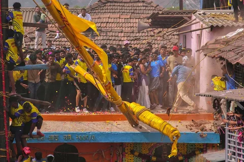 Para penonton mundur ketika sebuah tiang bambu yang dihias patah beberapa saat setelah diangkat selama ritual dalam festival tahunan berusia berabad-abad untuk menghormati dewi Raiba Devi di desa Rave, dekat Mumbai, Jumat (17/04/2026).
