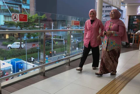 Pekerja wanita dengan mengenakan kebaya berjalan pulang kantor di kawasan Bunderan HI, Jakarta, Selasa (21/04/2026).