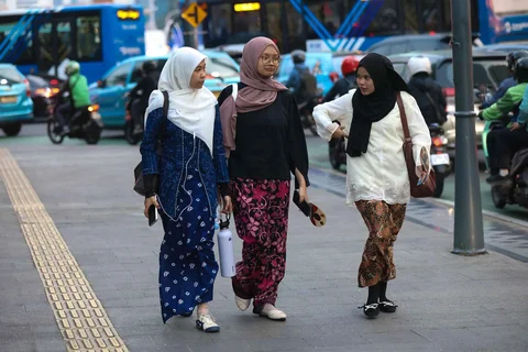 Pekerja wanita dengan mengenakan kebaya berjalan pulang kantor di kawasan Bunderan HI, Jakarta, Selasa (21/04/2026).
