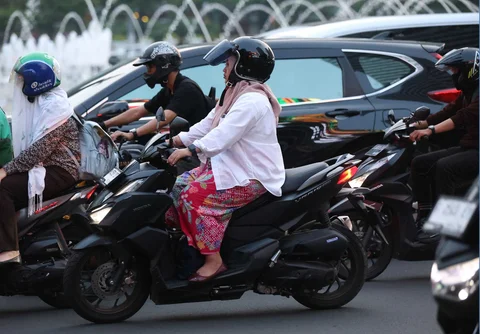 Pekerja wanita dengan mengenakan kebaya berjalan pulang kantor di kawasan Bunderan HI, Jakarta, Selasa (21/04/2026).