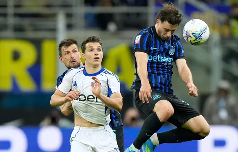 Pemain Inter Milan Carlos Augusto, menyundul bola di samping   pemain Como  Anastasios Douvikas pada  pertandingan Semifinal Copa Italia Leg-2, di Milan, Italia, Selasa (21/04/2026).