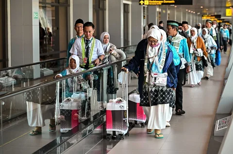 Para jemaah calon haji berjalan menuju gerbang keberangkatan pesawat di Terminal 1 Bandara Internasional Juanda Surabaya di Sidoarjo, Jawa Timur, Rabu (22/4/2026).