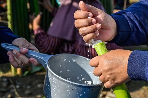 Peserta memasukkan beras ketan  ke dalam bambu saat proses memasak lemang (theut leumang) di bantaran sungai Desa Lhueng Asan, Aceh Barat Daya (Abdya), Aceh, Sabtu (25/4/2026).