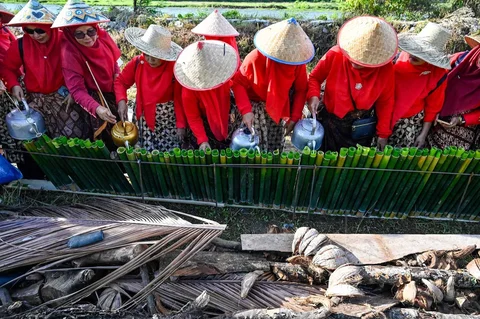 Peserta menuangkan santan ke dalam bambu saat proses memasak lemang (theut leumang) di bantaran sungai Desa Lhueng Asan, Aceh Barat Daya (Abdya), Aceh, Sabtu (25/4/2026).