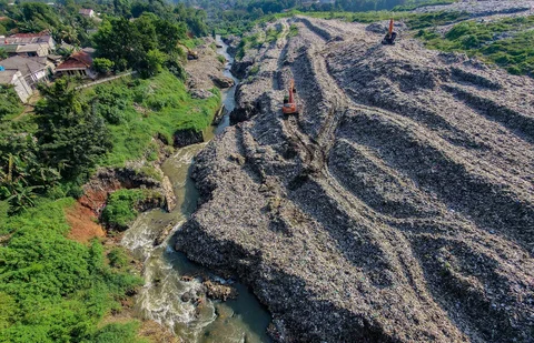Becho memadatkan gunungan sampah untuk menghindari longsor  TPA Cipayung pada Kali Pesanggrahan di kawasan Pasir Putih, Depok, Jawa Barat, Senin (27/04/2026).