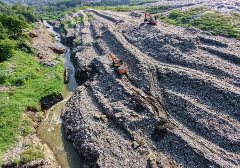 Becho memadatkan gunungan sampah untuk menghindari longsor  TPA Cipayung pada Kali Pesanggrahan di kawasan Pasir Putih, Depok, Jawa Barat, Senin (27/04/2026).