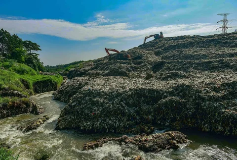 Becho memadatkan gunungan sampah untuk menghindari longsor  TPA Cipayung pada Kali Pesanggrahan di kawasan Pasir Putih, Depok, Jawa Barat, Senin (27/04/2026).