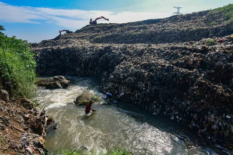 Warga mendulang benda-benda logam pada aliran Kali Pesanggrahan yang menyempit alibat longsoran timbunan sampah TPA Cipayung di kawasan Pasir Putih, Depok, Jawa Barat, Senin (27/04/2026).
