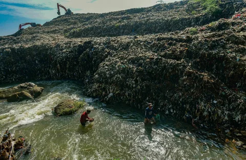 Warga mendulang benda-benda logam pada aliran Kali Pesanggrahan yang menyempit alibat longsoran timbunan sampah TPA Cipayung di kawasan Pasir Putih, Depok, Jawa Barat, Senin (27/04/2026).