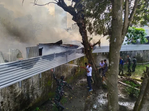 Prajurit TNI Angkatan Laut dari Kodaeral VIII bersama petugas dan warga memadamkan kebakaran di permukiman Kelurahan Kairagi Weru, Kota Manado, Selasa (28/4/2026).