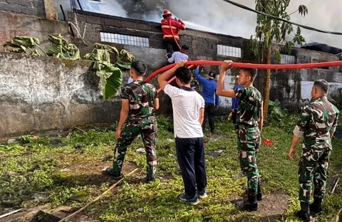 Prajurit TNI Angkatan Laut dari Kodaeral VIII bersama petugas dan warga memadamkan kebakaran di permukiman Kelurahan Kairagi Weru, Kota Manado, Selasa (28/4/2026).