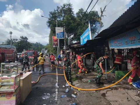 Prajurit TNI Angkatan Laut dari Kodaeral VIII bersama petugas dan warga memadamkan kebakaran di permukiman Kelurahan Kairagi Weru, Kota Manado, Selasa (28/4/2026).